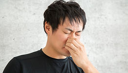 鼻を押さえる男性