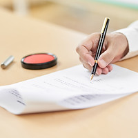 契約書にサインをする高齢者の手元
