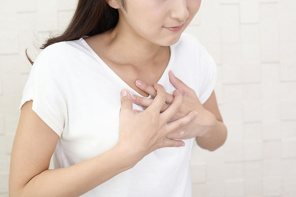 胸を押さえる女性