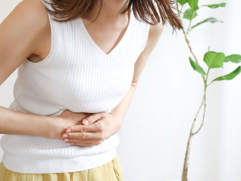 お腹を押さえる女性