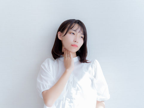 喉を押さえる女性
