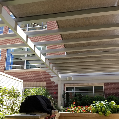 Pergola enhanced with solar fabric, blocking UV rays while maintaining a sleek and modern design