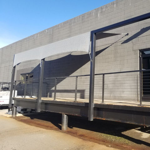 Residential steel pergola with solar shade material, providing UV protection and a stylish upgrade to outdoor spaces