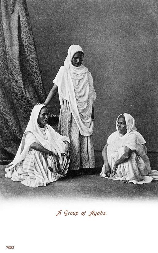 A black and white image of three ayahs, two seated and one standing. They are wearing traditional dress.