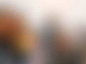 Indigenous community members speak at a public gathering, holding documents and a microphone, with protest banners visible behind them.