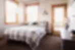 Rustic bedroom with queen bed, plaid bedding, and mountain lodge decor at Teton Basecamp near Driggs Idaho