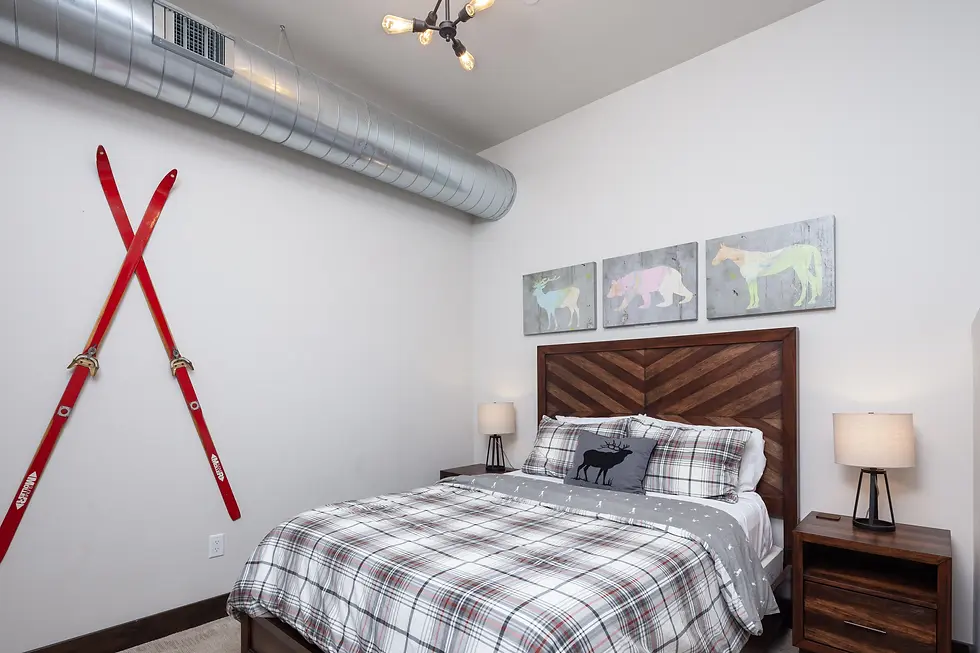 Mountain-themed bedroom with wooden chevron headboard and plaid bedding, ideal for paddleboarding adventurers visiting
