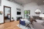 Modern living room at Glacier Adventure Loft in downtown Whitefish Montana with gray sofa, wood floors, and deck access