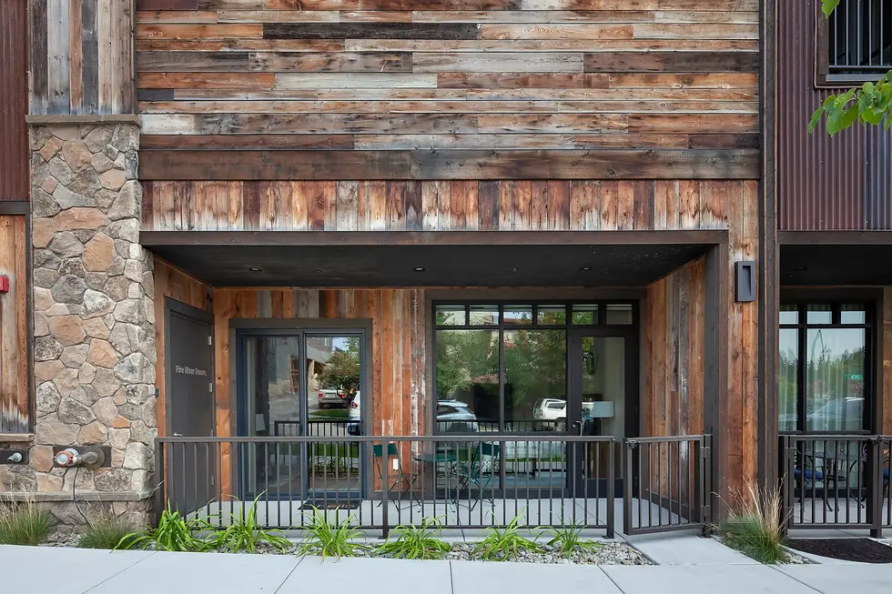 Modern mountain lodge entrance with stone chimney and wood siding representing fine dining in Whitefish MT at a historic log