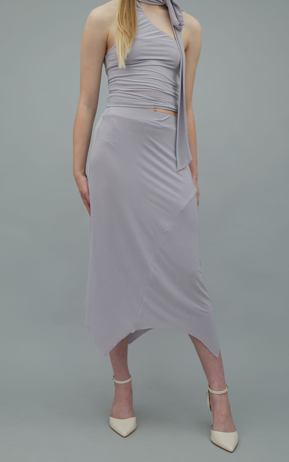 Lilac grey midi skirt with fitted waistband, body-skimming fit, and asymmetric handkerchief hem with angled pointed panels