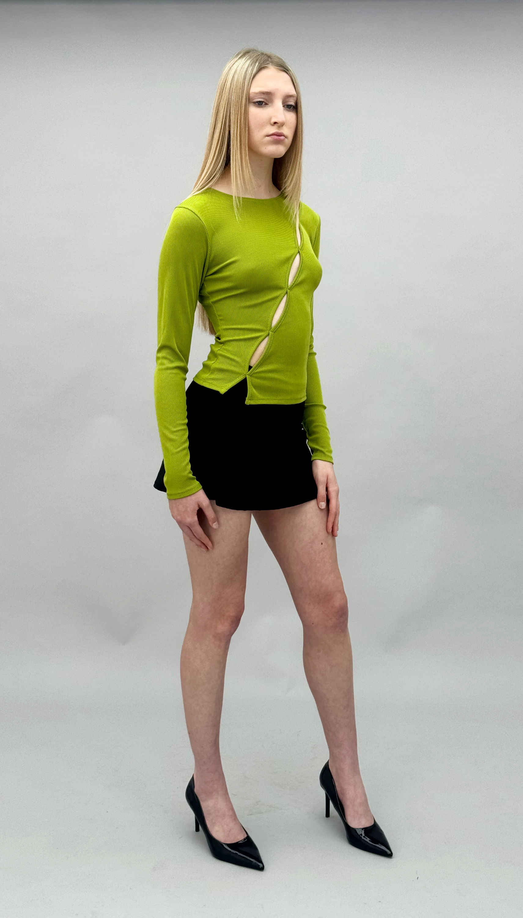 Lime green ribbed long-sleeve top with a boat neckline & asymmetric line of circular cut-out details down the front and side