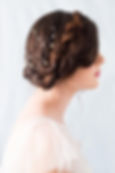 Head and shoulder shot of bride with braided hair accessorised with a pearl and crystal hair pin 