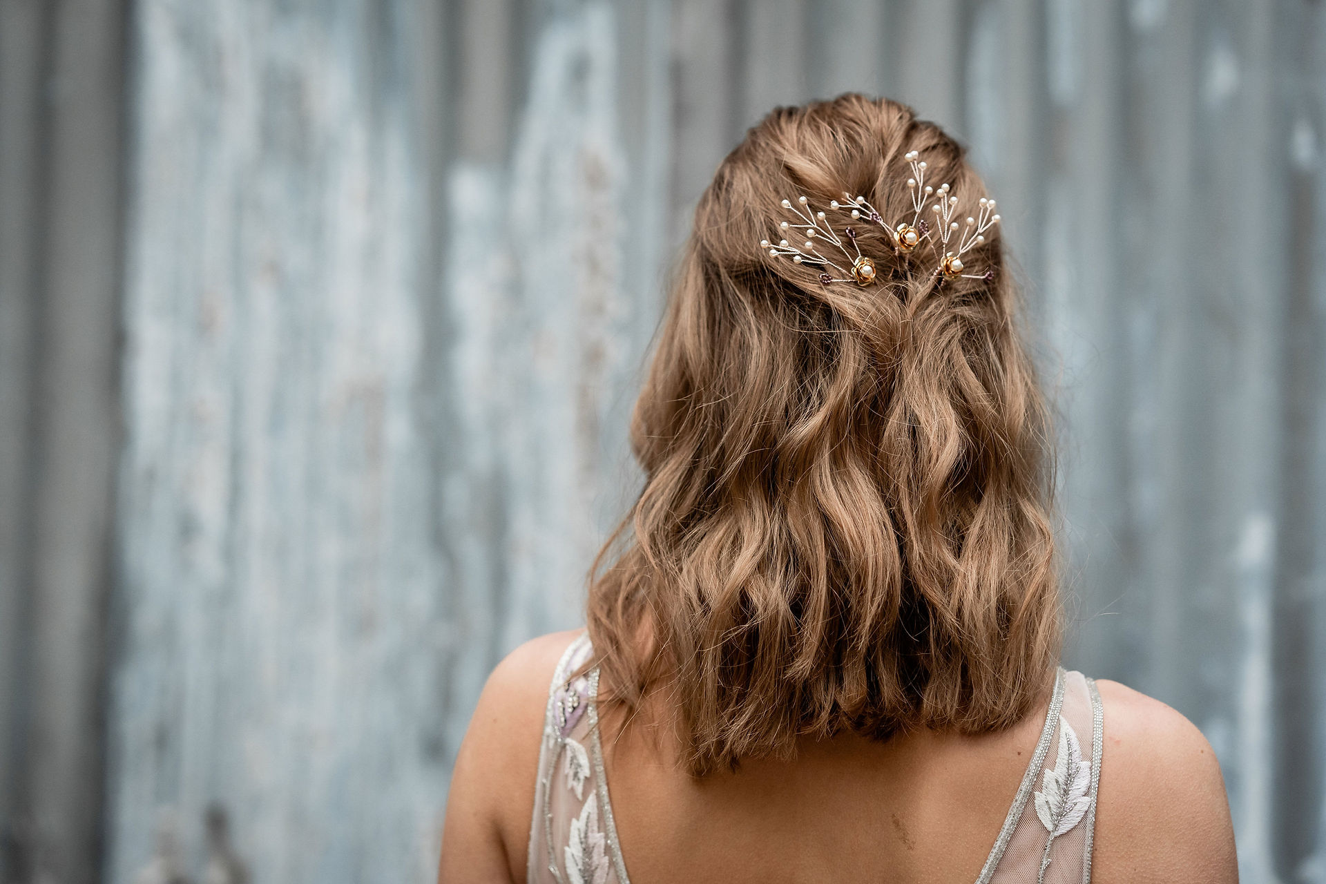 ORLA | Gold flower wedding hair pins styled in dark blonde bride's waved half up do hairstyle