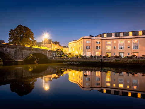 Reflections of a bridge across the River Dart at Totnes at dusk