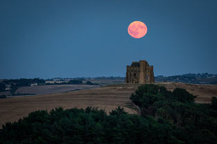 The July Buck Moon rising over the old chapel on the hill at Abbotsbury, West Dorset. By Dorset photographer, Gary Holpin