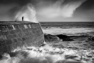 A man watching stormy seas on the Cobb at Lyme Regis, Dorset, by Devon photographer, Gary Holpin Photography