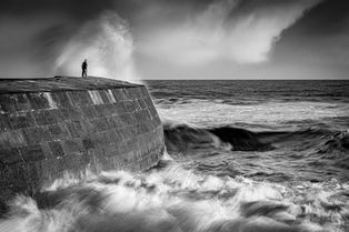 A man watching stormy seas on the Cobb at Lyme Regis, Dorset, by Devon photographer, Gary Holpin Photography