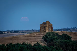 The July Buck Moon rises from the misty sky above the old chapel on the hill at Abbotsbury, West Dorset. By Dorset photographer, Gary Holpin
