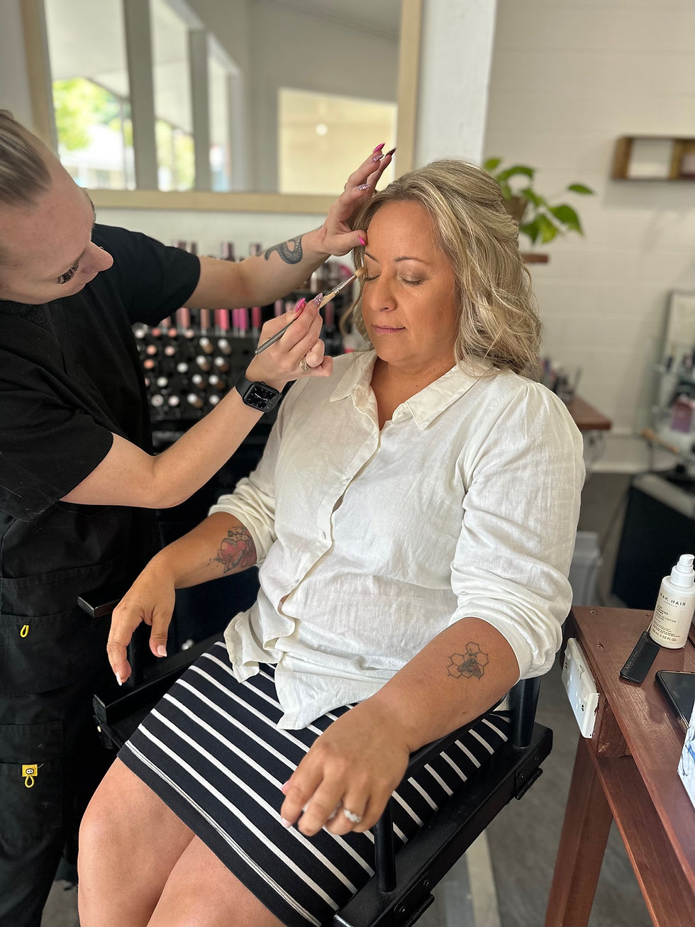Woman receiving makeup application at salon