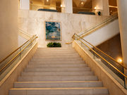 the-laura-hotel-downtown-houston-lobby-grand-staircase.jpg Alt text: Grand staircase inside The Laura Hotel in downtown Houston, with warm lighting, pale stone, and arched ceilings above.