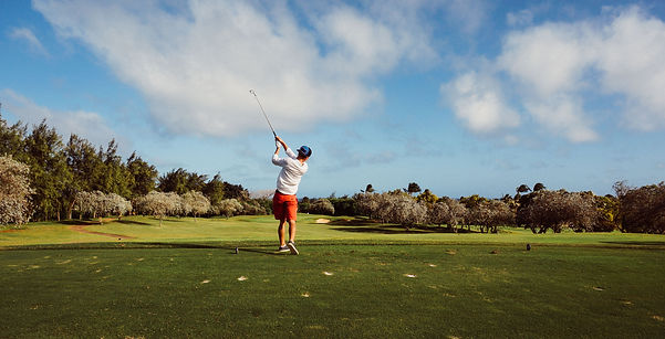 A young golfer tees off