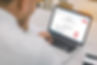 En person som tittar på sin dator och öppna kurstillfällen inom Personalutbildning för företag i brand, utrymning, Hjärt- och lungräddning (HLR) och Första hjälpen