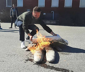 Man tränar på att släcka en brand i kläder på en docka under en utbildning i brandskydd
