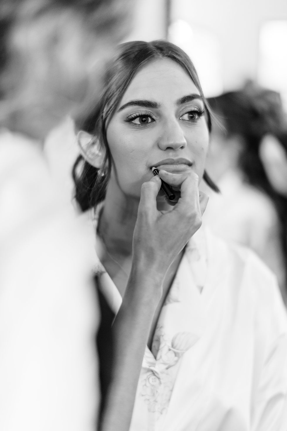 Eye-level view of a bridal hair stylist arranging a bride's hair in a salon