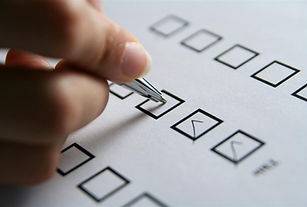 Picture shows hand checking a multiple box sheet of white paper with a pen.