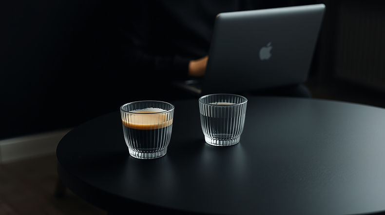 Two glasses with coffee and water on table