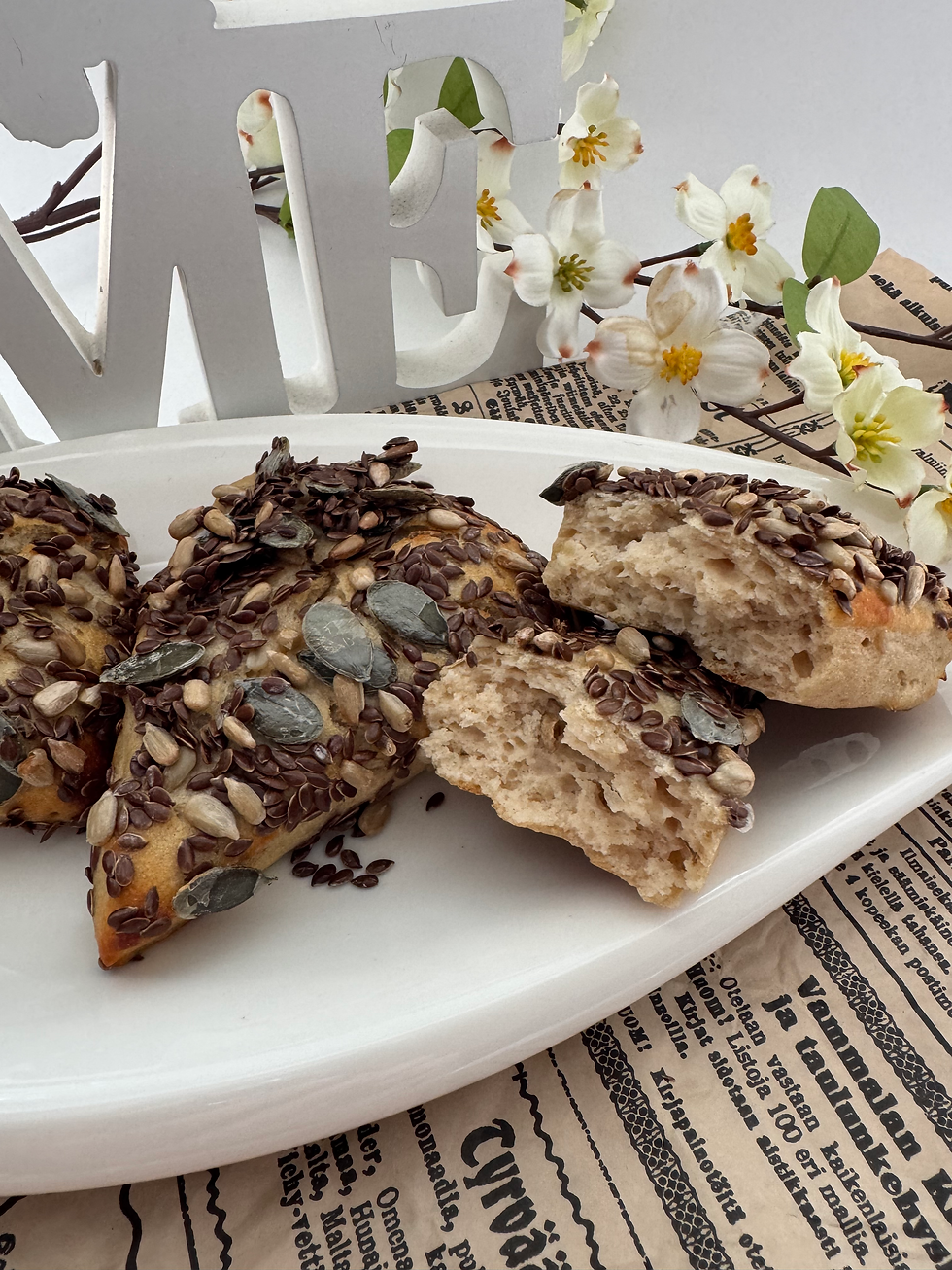 frischgebackene Körnerspitzen mit verschiedenen Körner belegt. Dahinter Blumendeko