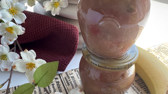 weinrotes Geschirrtuch, Banane, Marmeladengläser, Steinvase, Blüten