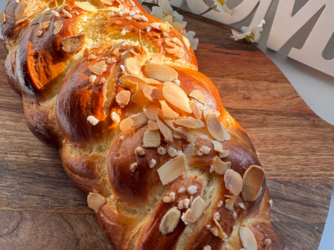 Germteigstriezel auf Holzbrett, weiße Blüten, Home-Deko