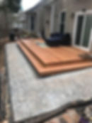 Multi-level deck builds with stone patio and furniture.