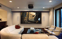 Modern media room with wall-mounted display, in-wall speakers, and minimalist AV setup by SmartVolt.