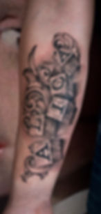 Realistic black and grey tattoo of a name on wooden alphabet blocks, by Dagga