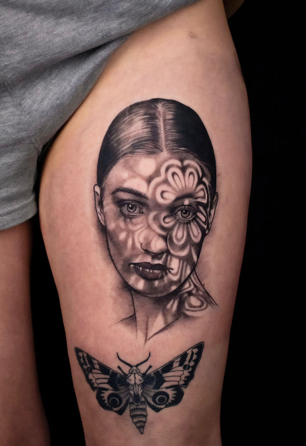 Realistic black and grey tattoo portrait of a woman with light and shadows, by Dagga
