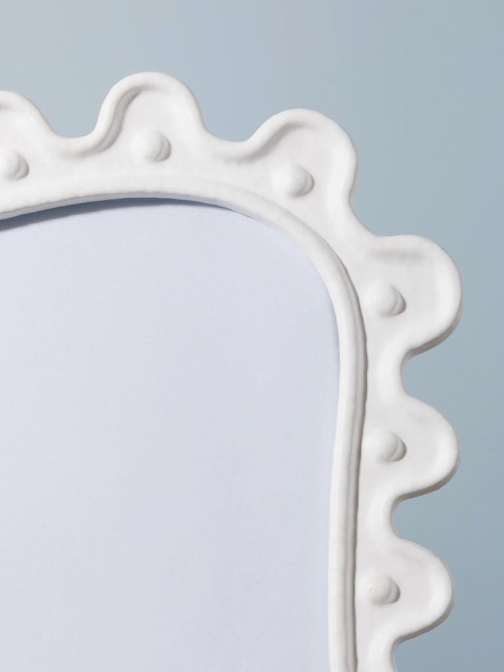 Détail du contour ondulé et sculptural du grand cadre photo Anima.