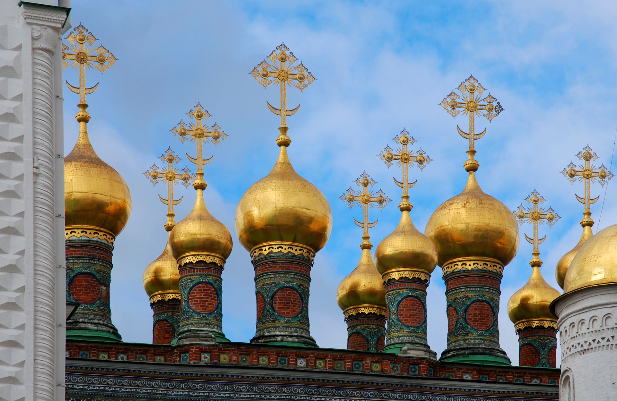 The gold onion domes of the Moscow Kremlin cathedrals above their tiled drums.