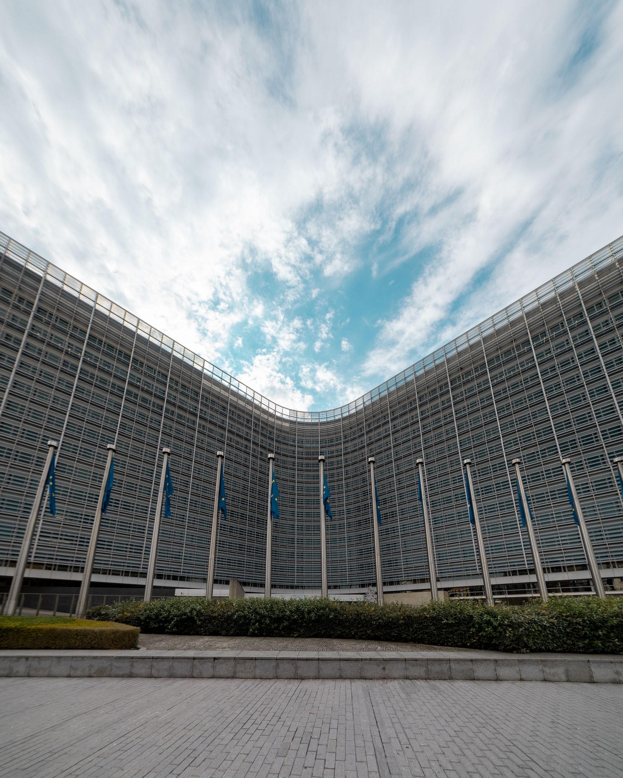 The Berlaymont building in Brussels with a row of European Union flags.