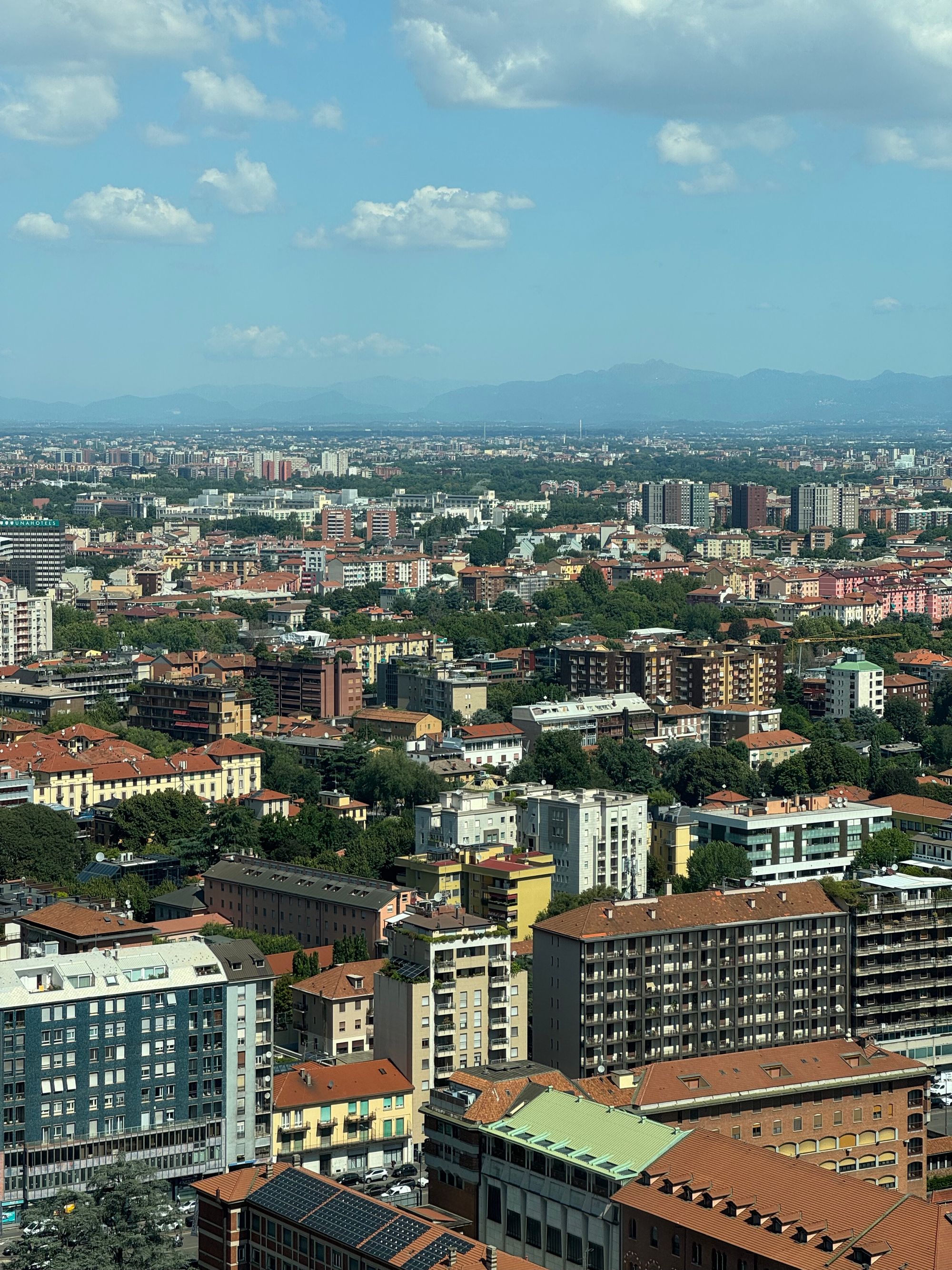 Modern skyscrapers in the Milan skyline under a clear sky.