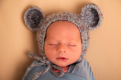 תינוק מקורב על כובע דובי צבע כחול