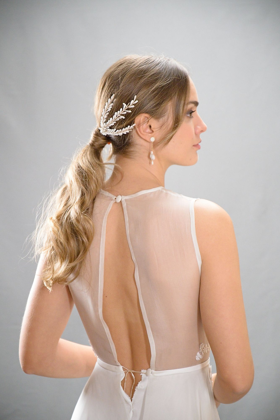 Miniature : Accessoire de chignon porté à l’arrière, composé d’éléments blancs en porcelaine froide disposés symétriquement autour d’un c