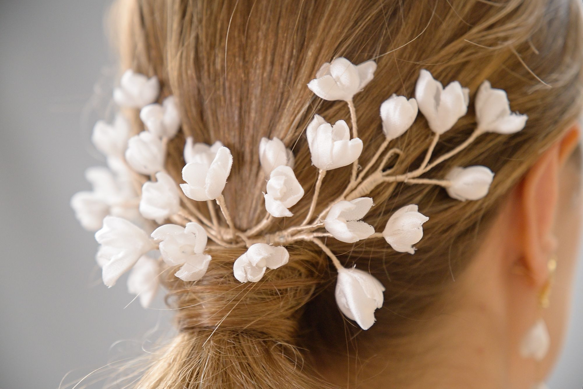 Accessoire de mariée en fleurs de soie blanches, orné de délicates fleurs , à placer à l’arrière de la coiffure.