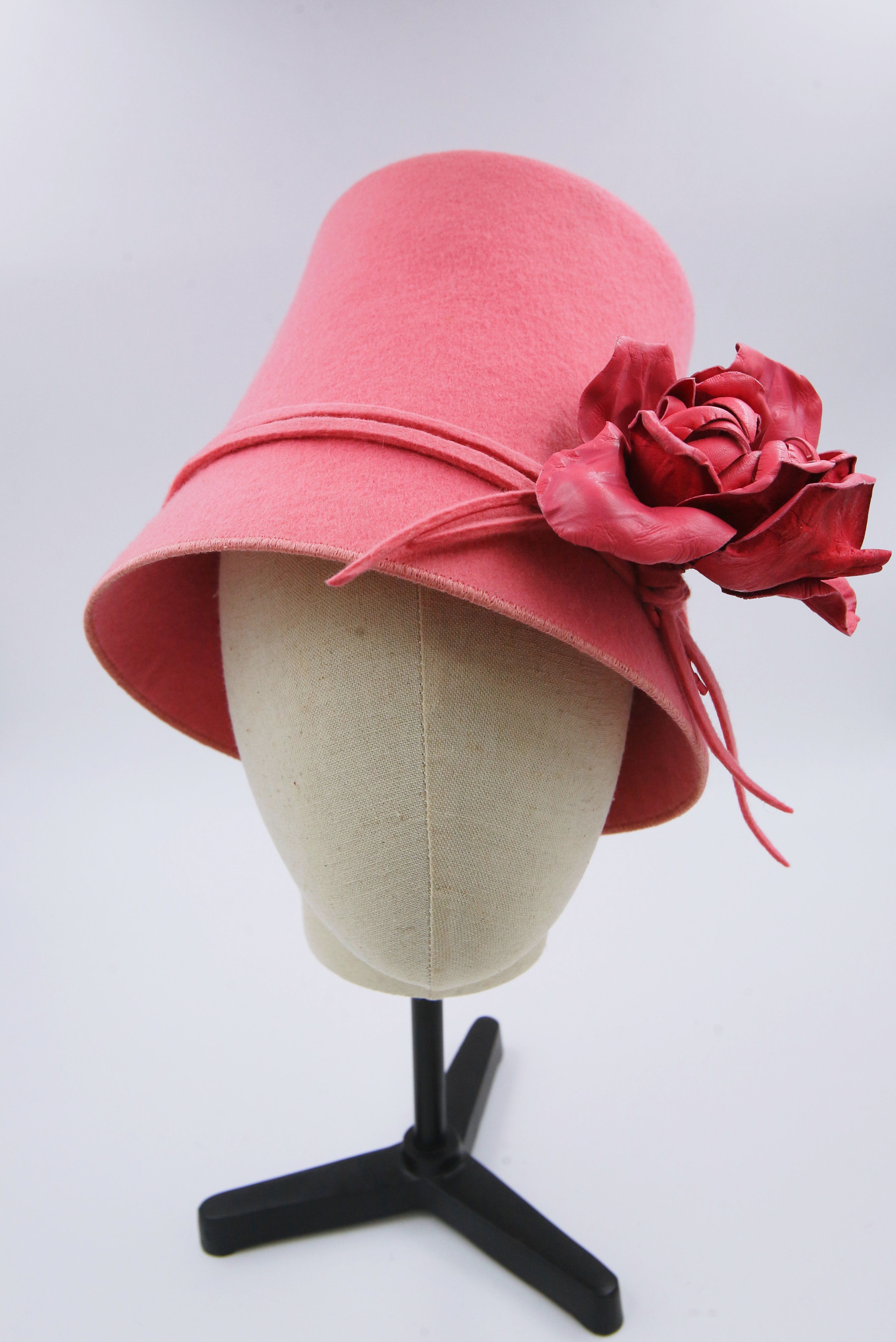 Chapeau en feutre rose. Avec une rose en cuir assortie, c'est un chapeau avec une forme de couronne haute qui rappelle une coupe de champagne inversée.