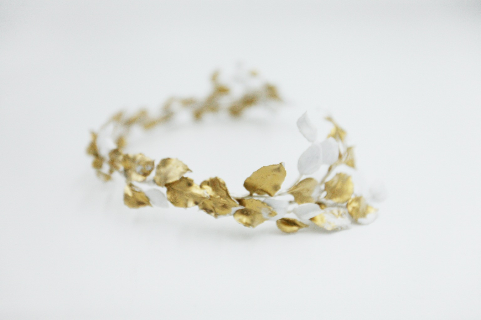 Accessoire de coiffure de mariée en porcelaine froide, composé de feuilles dorées et blanches inspirées des déesses grecques.