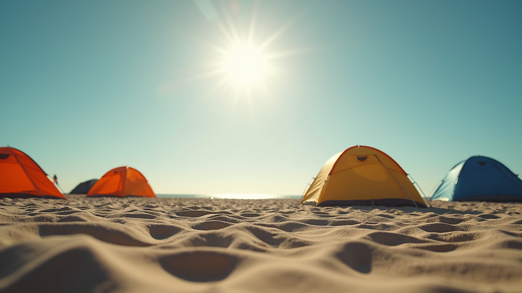 Eye-level view of a sandy beach campground with tents under the sun