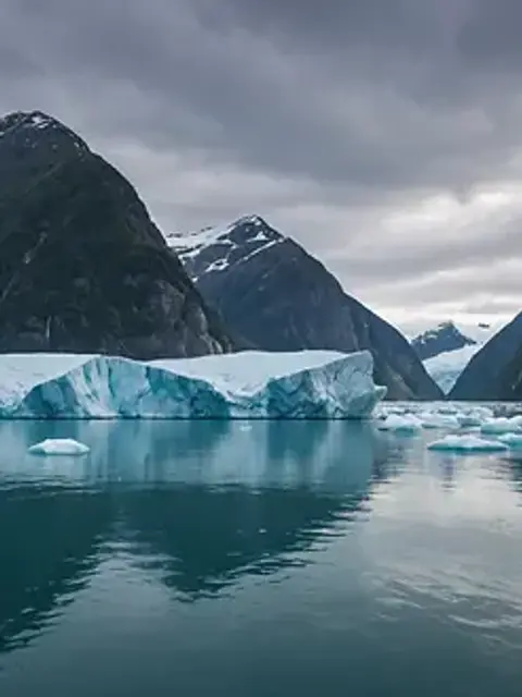 Wide angle view of dramatic cliffs and floating icebergs in Tracy Arm Fjord