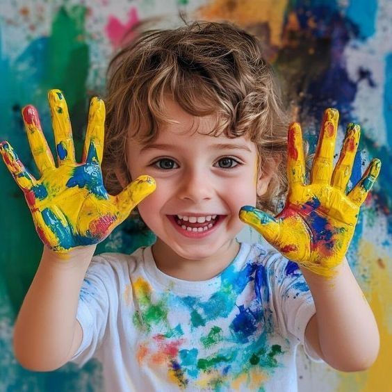 Child showing colourful painted hands during a creative painting activity
