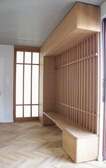 Vollholzgarderobe mit Sitzbank und japanischer Holzschiebetür mit Sprossen und satiniertem Glas in Eichenholz